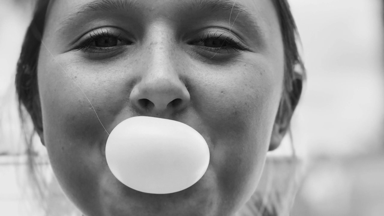 Woman blowing chewing gum bubble